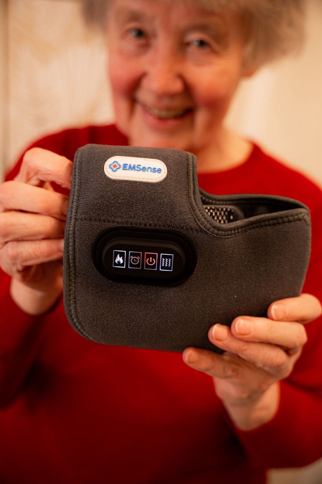 Woman smiling and holding the EMSense foot massager